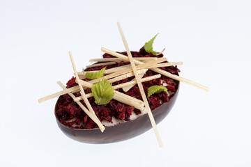 Chocolate egg dessert filled with passion fruit mousse decorated with chopped cranberries isolated on white