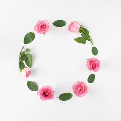 Pink roses arranged in a circle and place for message in the middle. Flat floral concept on white background.