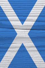 Scottish flag on a dry wooden surface. Natural vertical background, wallpaper or backdrop made of...