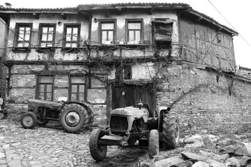 Obraz premium selective focus. old tractors and old village houses in Bursa in Turkey's history has been abandoned.