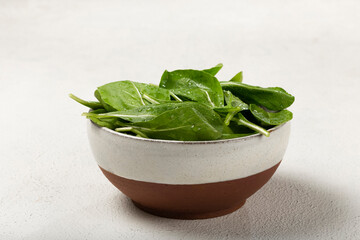 Arugula salad in a bowl on white background.