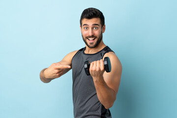 Young sport man with beard making weightlifting and pointing it