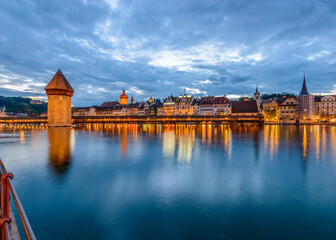 Obraz premium Night view towards Chapel Bridge (Kapellbruecke) together with the octagonal tall tower (Wasserturm) it is one of the Lucerne's most famous tourists attraction