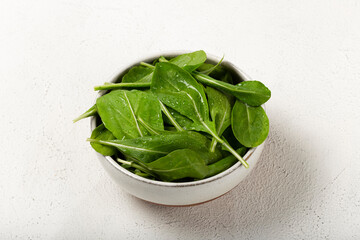 Arugula salad in a bowl on white background.