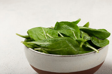 Arugula salad in a bowl on white background.