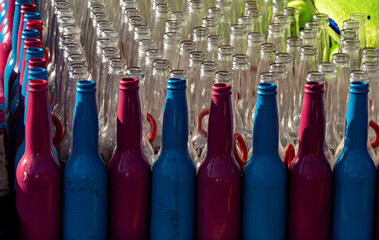 Red, blue and clear beverage bottles with no lids.