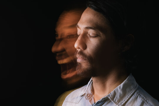 Portrait of a relaxed and calm Latin man with his eyes closed next to a distorted image of himself screaming and annoyed. Long exposure image. Double personality. Mental illness concept