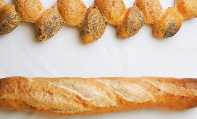 Fresh baked bread loafs on a white tablecloth