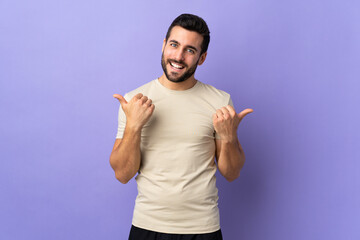 Young handsome man with beard over isolated background with thumbs up gesture and smiling