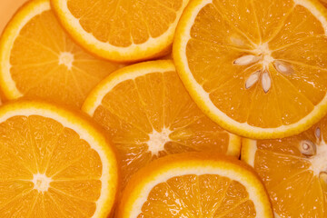 slices of orange fruit, top view. Orange background texture