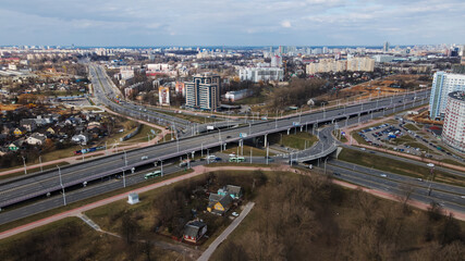 Large transport interchange in a big city. There is a lot of public transport on the road. Aerial photography.