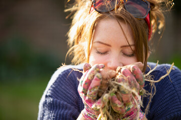 Close up woman smelling fresh harvested potatoes