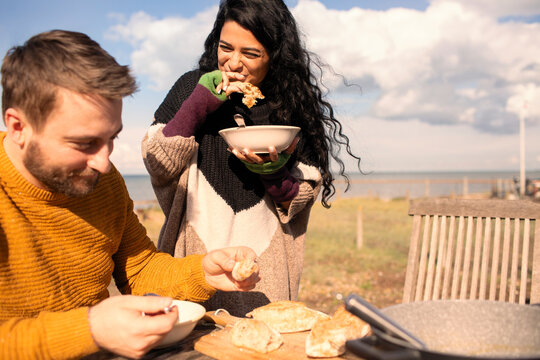 Happy couple eating on sunny beach patio