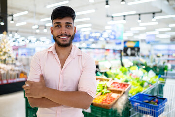 Latin American at the supermarket. Smiling man with arms crossed and looking at camera