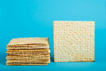 Matzo plates laid on top of each other on a blue background. copy space.