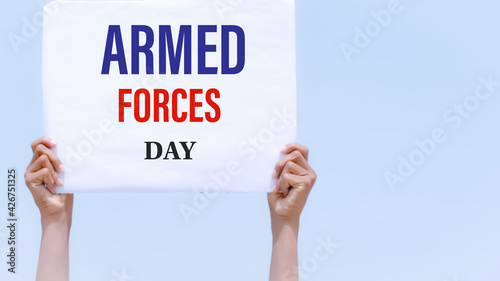 Armed forces day with banner in hand in sky background