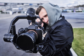 Video camera operator working with professional equipment close up