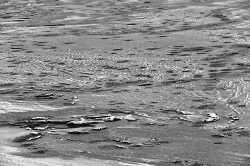 Park under snow against the background of the frozen river