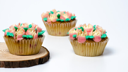 Three cupcakes on a wooden plate