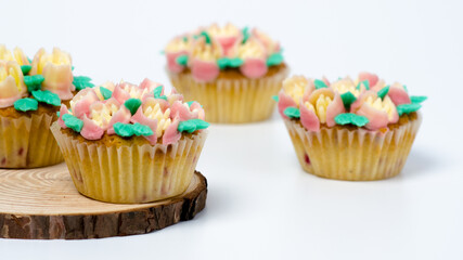 Four cupcakes on a wooden plate