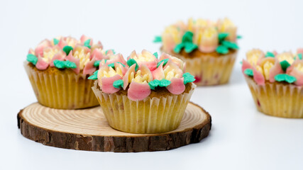 Four cupcakes on a wooden plate