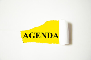 agenda the text is written on a white background and a yellow piece of paper