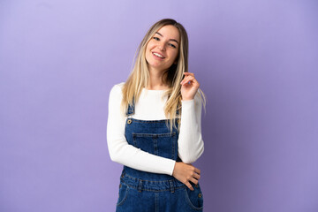 Young woman over isolated purple background laughing