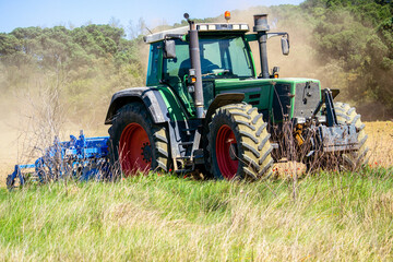 tractor plows a field on a farm in a village, agriculture