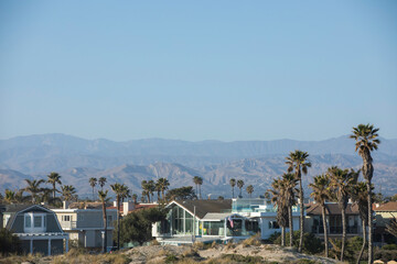 Sunset view of coastal dunes and houses in Oxnard, California, USA.