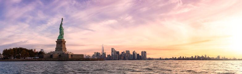 Panoramic view of the Statue of Liberty and Downtown Manhattan in the background. Dramatic Colorful Sunrise Artistic Render. Taken in Jersey City, New Jersey, United States. - obrazy, fototapety, plakaty