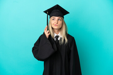 Young university graduate over isolated blue background with fingers crossing and wishing the best