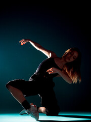Stylish dance artist posing against dark backgorund