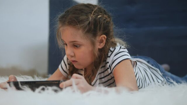 little girl playing handheld a game console. kids dream stay home computer addiction. girl playing tablet online games. addiction to online games fun addict kid. child play game console dream