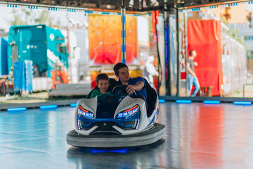 Smiling boy at the wheel toy electromobile