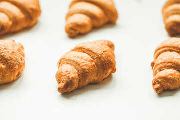 Fresh croissants in the plate on the warm white background with copy space. Homemade bakery