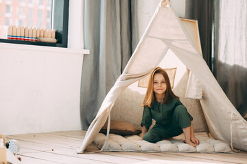 Girl reads a book in a children's hut at home © Ekaterina
