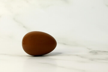 chocolate egg broken into pieces on a light background
