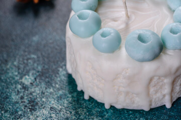 Beautiful colorful bright candle made in the form of an appetizing cake. Aromatherapy, candle with the smell of herbs