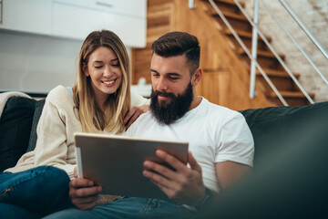 Couple using a digital tablet at home