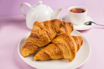 Continental breakfast with gold french croissants fruits and cup of tea