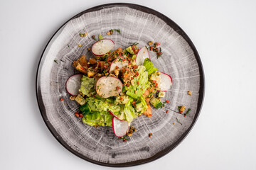 Fresh mix of salads with vegetables on a plate. Top view. Space for text