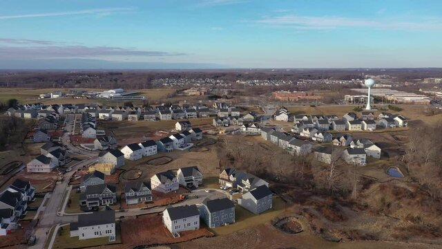 Circling above a modern upper middle class single family homes neighborhood street American real estate in a new construction area in Maryland USA, blue sky 4K	
