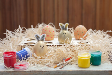 Easter composition of eggs on a background of hay. Children's creativity. Painting eggs.