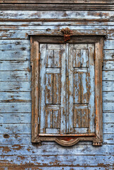 Window with shutters on an old blue wooden building. - 426763314