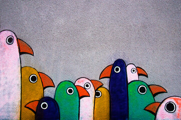 Street graffiti: minimalist multi-colored pogues in a row on a gray wall