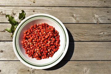 Fresh strawberries in a plate isolated on a wooden background. Top view of strawberries on the table. Summer fruits background, banner, copy space for text. View from above. Flat lay