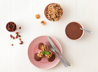 Pancakes stuffed with raisins and crushed walnuts, with chocolate cream topping. Top down view.