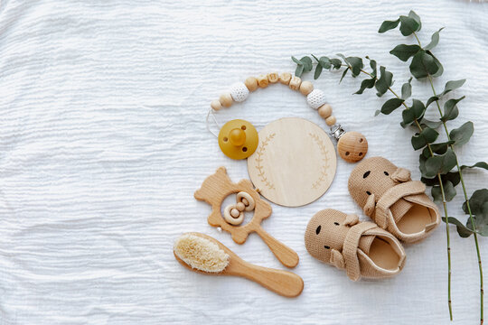 Newborn booties with empty card and wooden toys. Baby Background, top view, flat lay, copy space