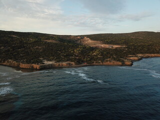 Beautiful view of the Cyprus landscape from above with a drone.  Juniper forest and rocky shore. Mediterranean sea at dawn. The nature reserve of the Akamas Peninsula