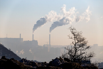 Pipes of thermal electrical space smoke in the tuan against the backdrop of a large city. Ecology in the city.